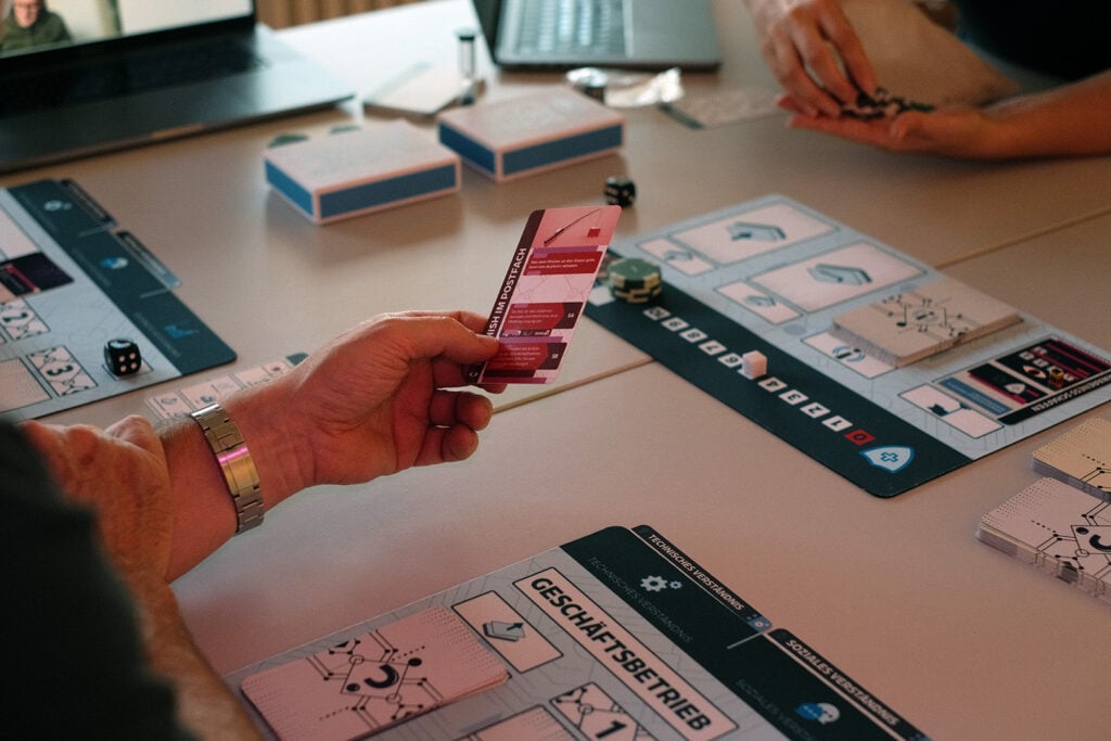Gamification in der IT-Sicherheitsschulung: Zwischen echtem Lerneffekt und Marketing-Buzzword 1 Gamification IT-Sicherheit: Beim Brettspiel Sicherheitsl_cke balancieren Teams über drei Geschäftsjahre Business und Sicherheit.
